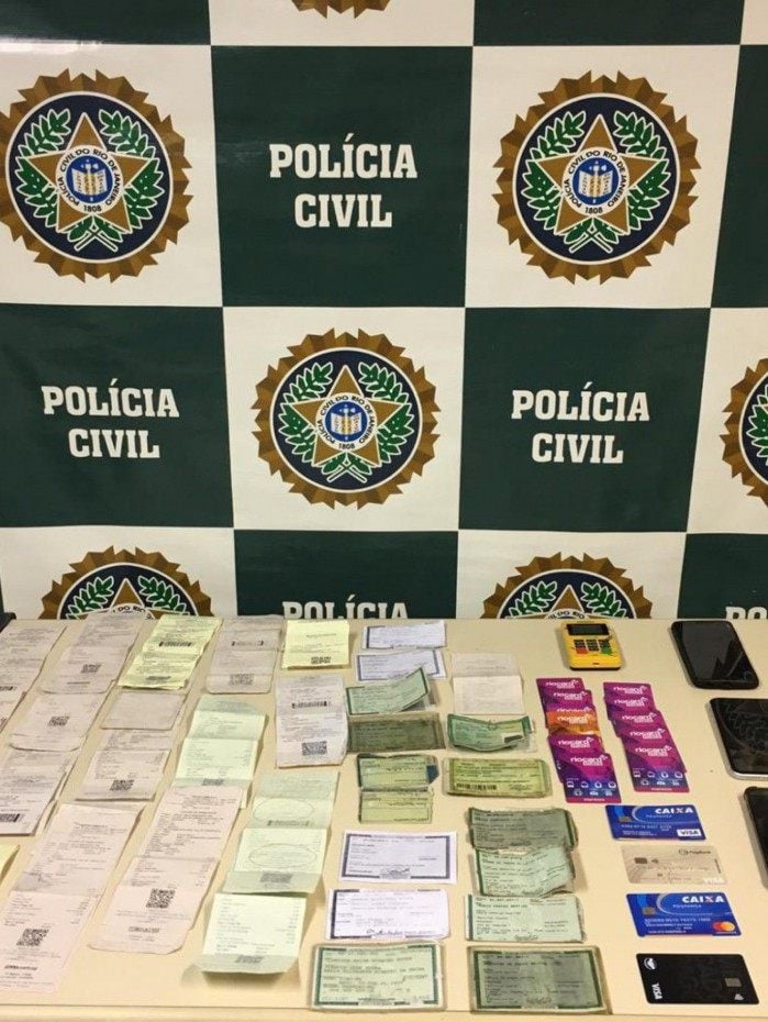  Com o trio, os policiais apreenderam documentos de identidade, cartões de credito, maquina de cartão, passagens e rio cards 