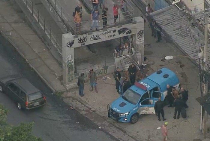 Policiais militares socorrem baleados em passarela da movimentada Avenida Martin Luther King, na altura do Morro do Juramento