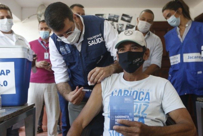 Secretário Daniel Soranz aplica a vacina em Dener Freitas, morador de rua 