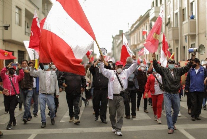 Apoiadores do candidato presidencial do partido Peru Libre, o esquerdista Pedro Castillo, marcham perto da sede do Júri Eleitoral Nacional (JNE) em Lima em 7 de junho de 2021, exigindo que Castillo seja declarado o vencedor do segundo turno das eleições presidenciais de 6 de junho.
