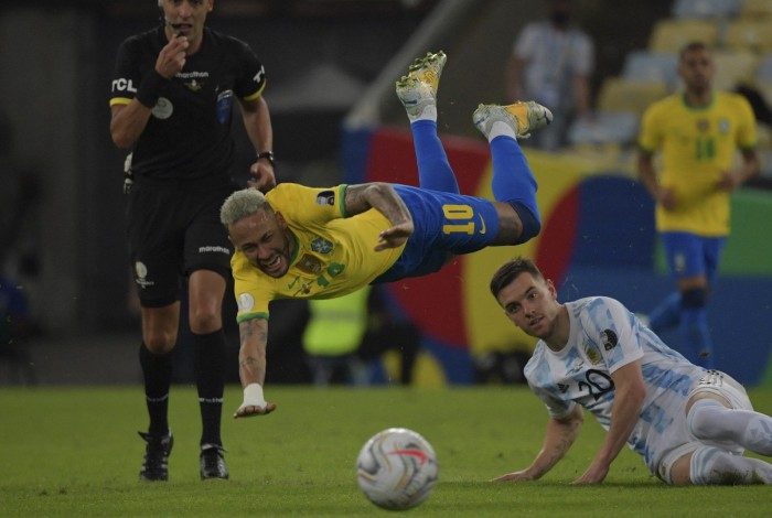 Brazil's Neymar (top) and Argentina's Giovani Lo Celso fall as Uruguayan referee Esteban Ostojich looks on during the Conmebol 2021 Copa America football tournament final match at Maracana Stadium in Rio de Janeiro, Brazil, on July 10, 2021. (Photo by NELSON ALMEIDA / AFP)