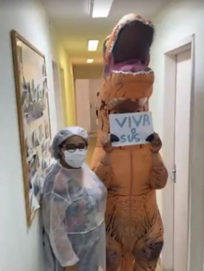 Mulher se fantasia de dinossauro e vai se vacinar em Niterói