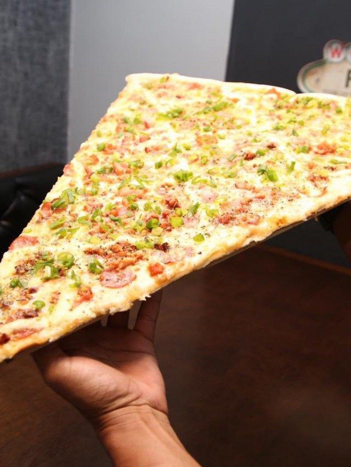 Maior fatia de pizza do Brasil tem 80cm e &Atilde;&copy; vendida em estabelecimento de Nova Igua&Atilde;&sect;u.