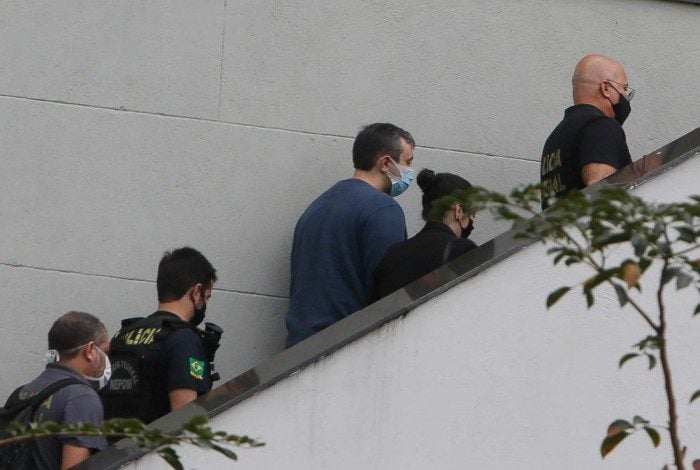 Raphael Montenegro (no detalhe e de camisa azul) chega à sede da Polícia Federal, na Praça Mauá 