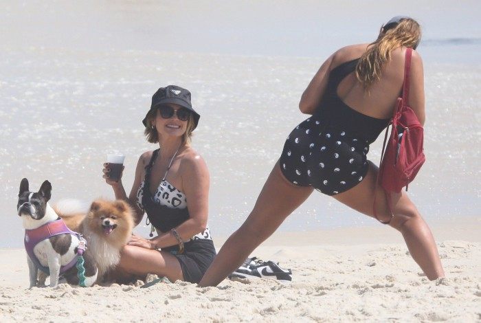 Flávia Alessandra e Giulia Costa passeiam com cachorros na praia da Barra da Tijuca