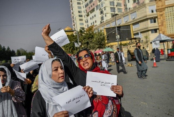 Mulheres afegãs seguram cartazes em protesto por direitos      