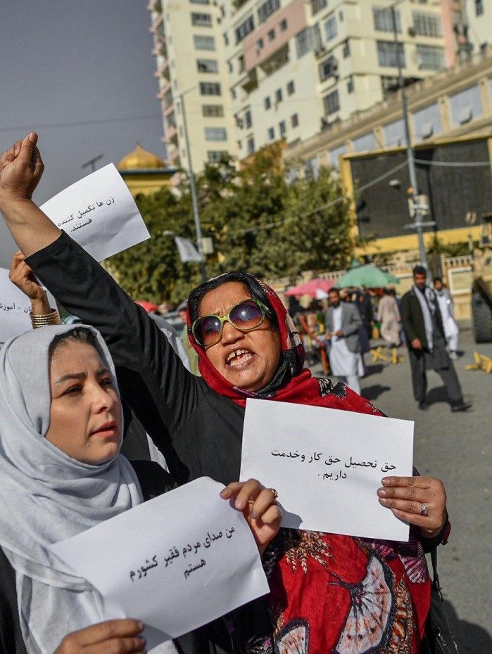 Mulheres afegãs seguram cartazes em protesto por direitos      