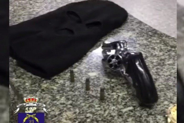 Um revólver, um aparelho de telefone celular e um relógio de pulso foram encontrados com o criminoso