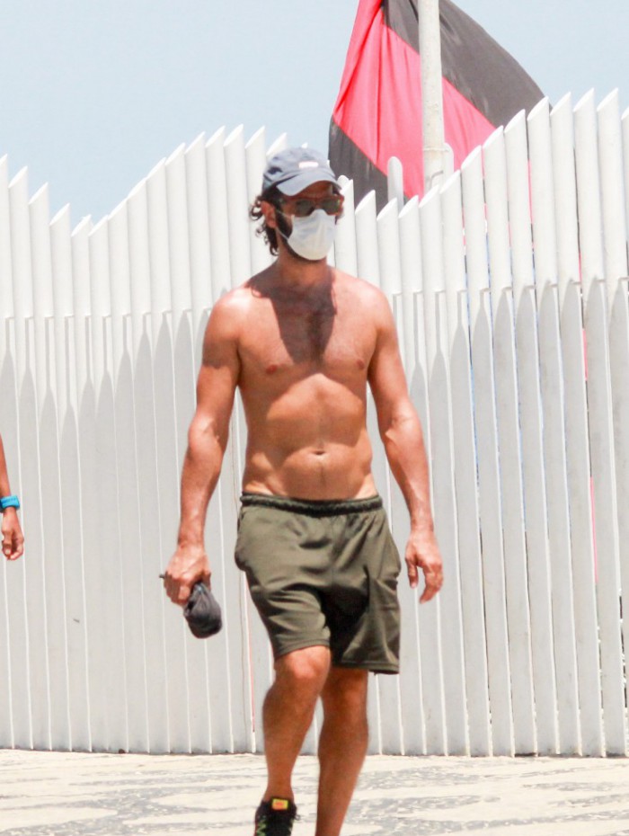 Rodrigo Santoro caminha na orla da praia do Arpoador