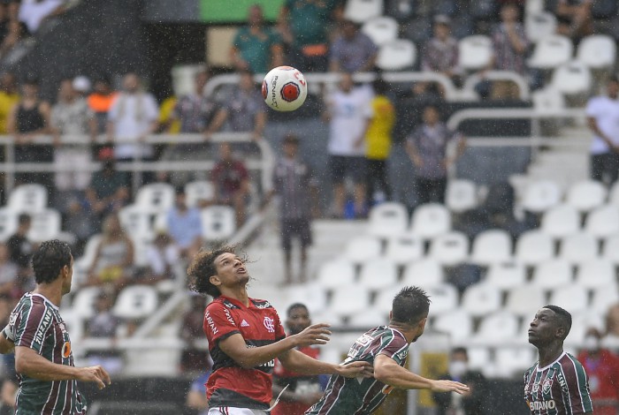 Willian Arão, do Flamengo, disputa bola com jogadores do Fluminense