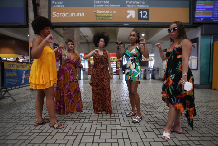 Na Central, um grupo de passageiras faz com os dedinhos o que acha do transporte pelos trilhos no Rio