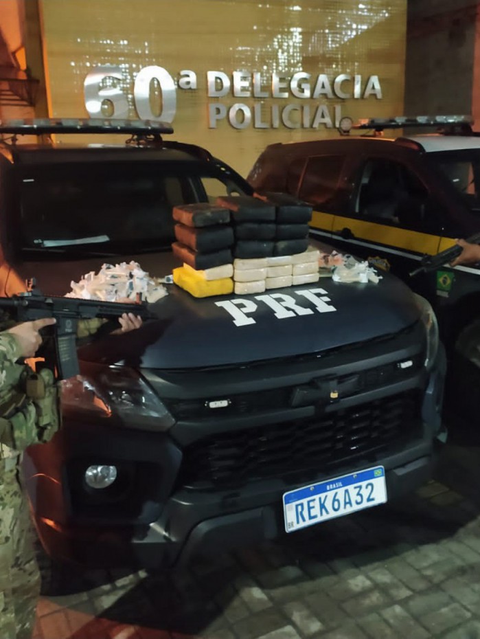 Policiais rodovi&aacute;rios federais com as drogas apreendidas