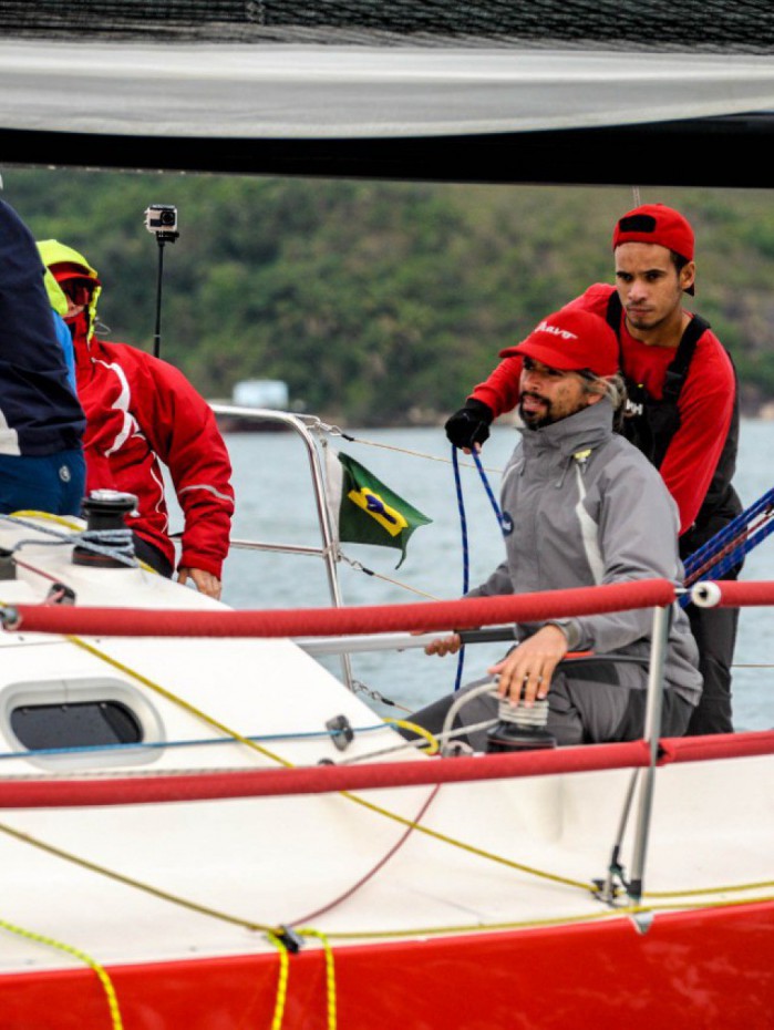 Barco Bravo e Alex Sandro de Carvalho (de cinza) em destaque no veleiro.