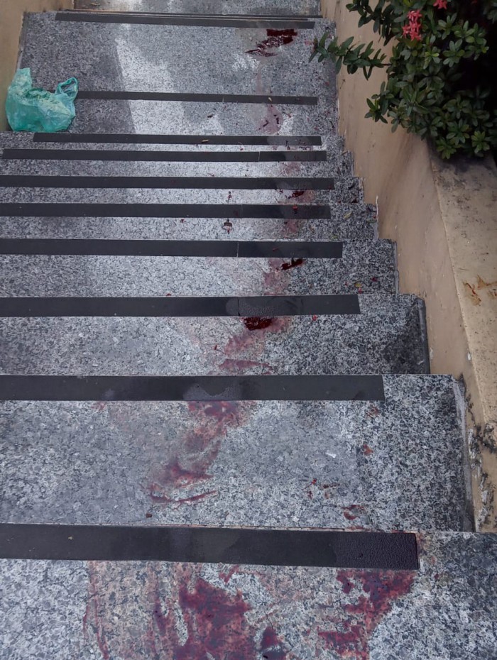 Manchas de sangue deixadas por um dos suspeitos no p&aacute;tio do pr&eacute;dio