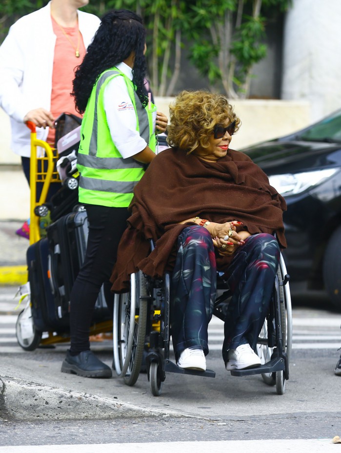 Alcione desembarca de cadeira de rodas em aeroporto do Rio
