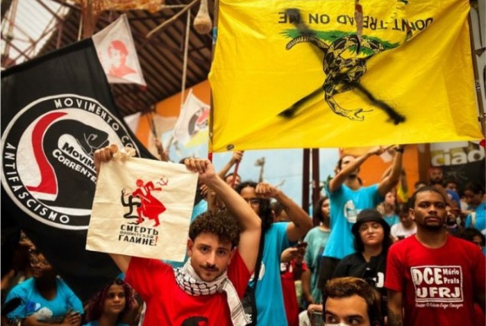 Movimentos revolucionários de esquerda exibem a bandeira roubada, que acabou sendo depredada e colocada de cabeça para baixo