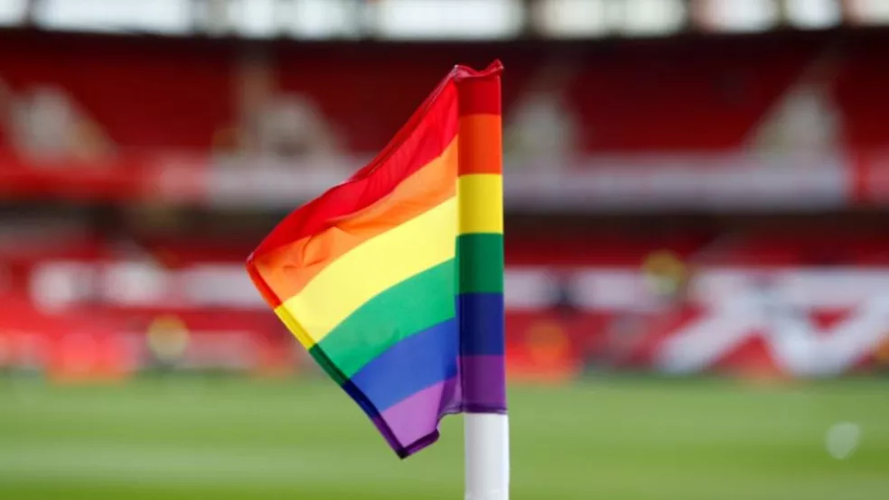 Bandeira LGBTQIA+ em campo de futebol
