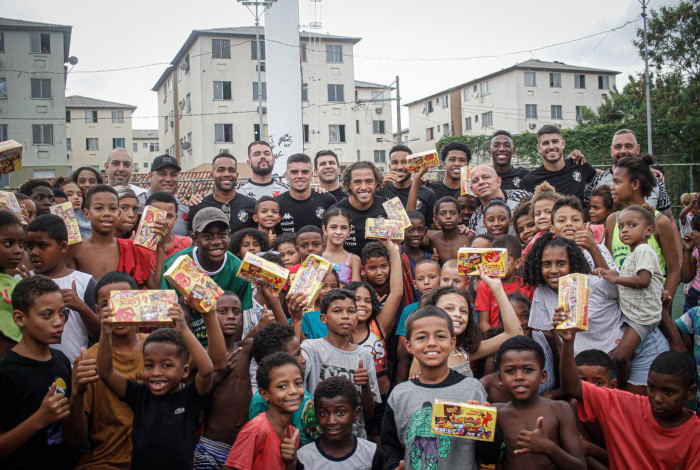 Jogadores do Vasco distribuem chocolates na Cidade de Deus