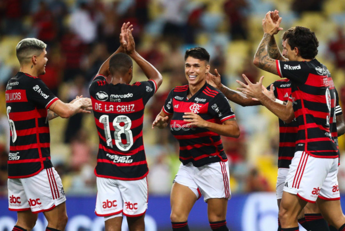 Autor do primeiro gol do Flamengo, Luiz Araújo é festejado pelos companheiros, no Maracanã, enquanto põe a bola sob a camisa para homenagear a gravidez de sua mulher