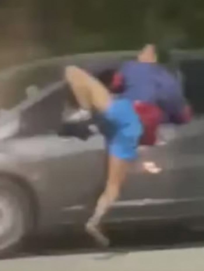 Nas imagens, o assaltante aparece preso na janela do veículo