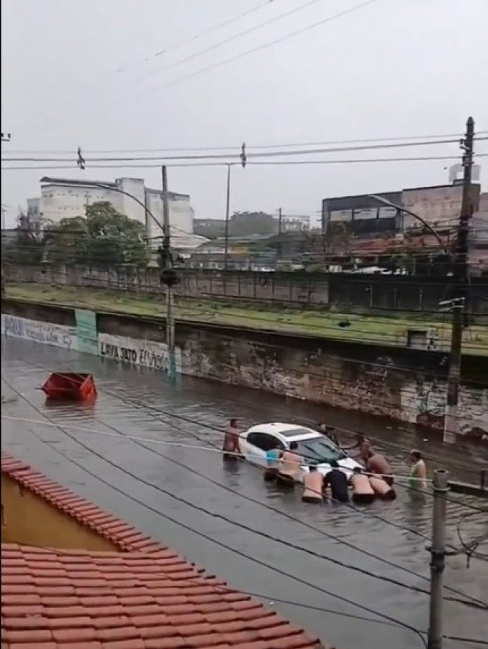 Carro ficou parcialmente submerso na Rua Uranos, em Bonsucesso