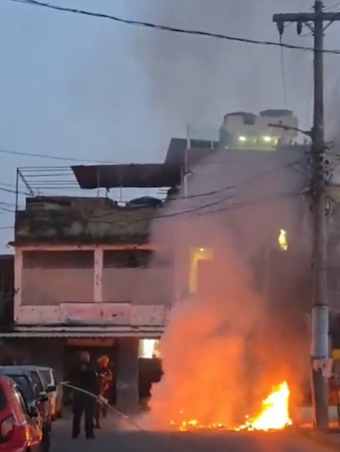 Policiais apagando o fogo de uma barricada com baldes de &aacute;gua