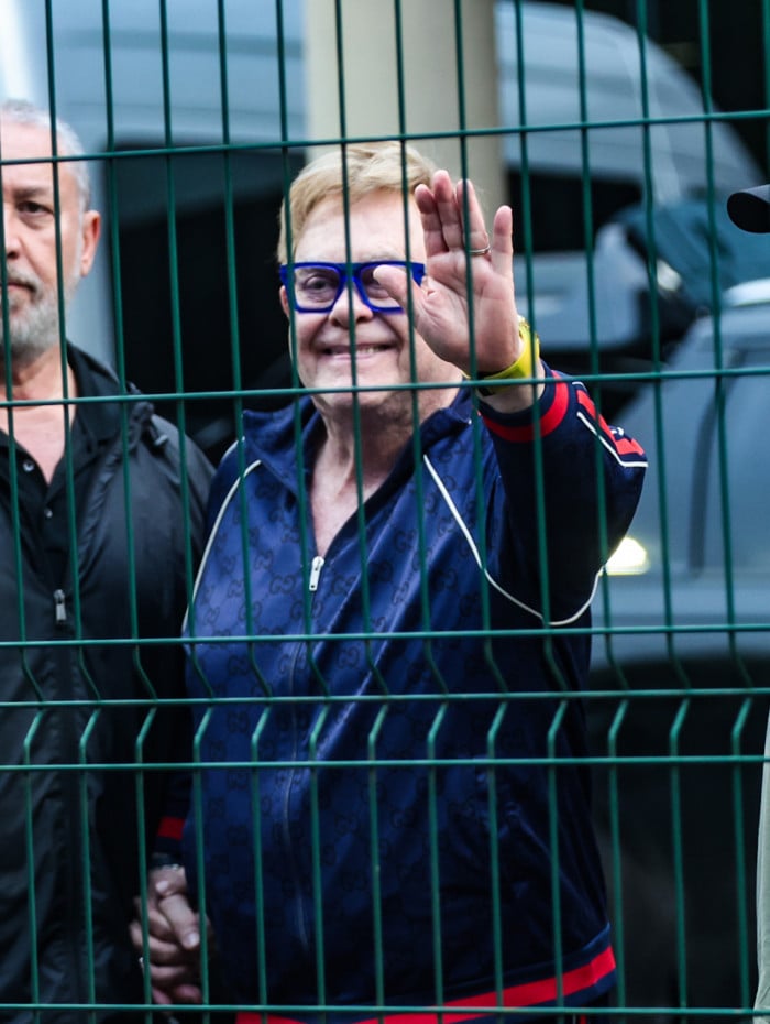 Antes de deixar o Brasil, Elton John acena para os f&atilde;s no aeroporto do Gale&atilde;o