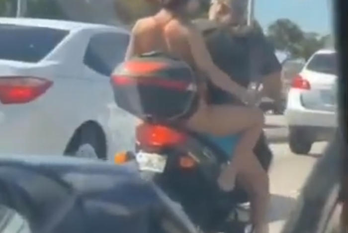 A mulher se depilando sobre uma moto