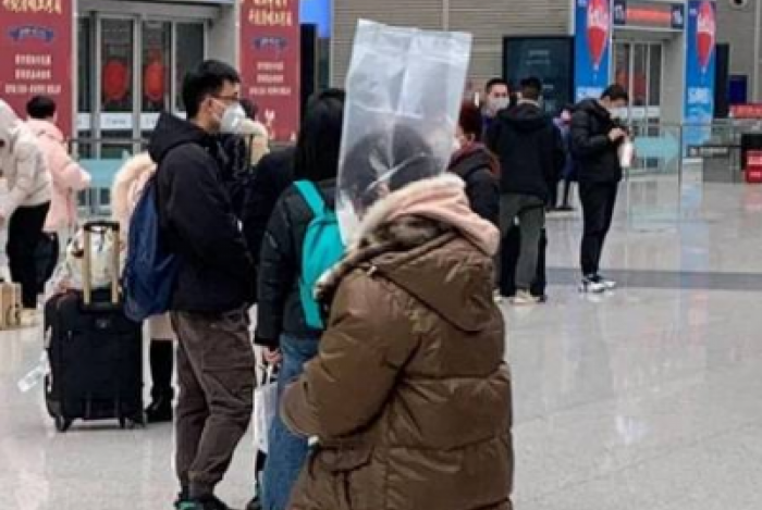 Passageira se protege com saco plástico em aeroporto